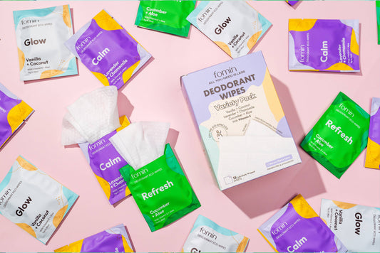 Various packages of Formin deodorant wipes on a pink background